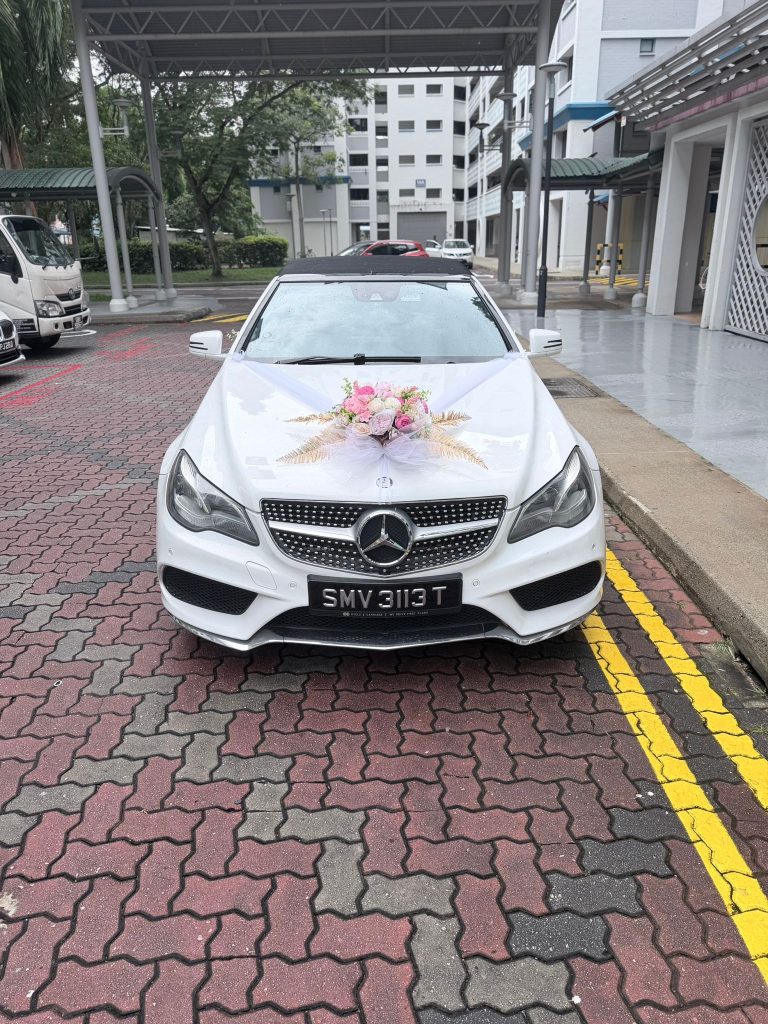 White Mercedes E-Class cabriolet dressed with ribbons for bridal car packages Singapore couples book