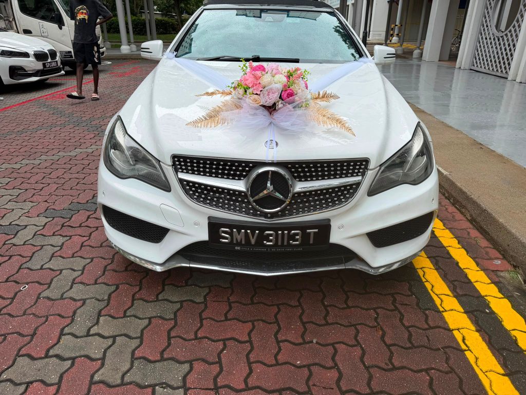 White Mercedes cabriolet with floral decoration ready for church wedding car rental Singapore
