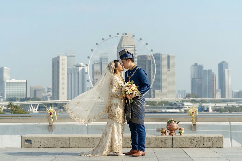 Malay wedding couple photographed at Marina Bay with the Singapore Flyer behind them.