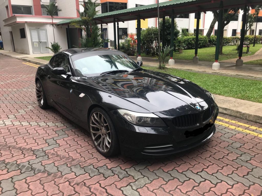 Black BMW Z4 roadster on a driveway before a sunset proposal sports car rental Singapore route